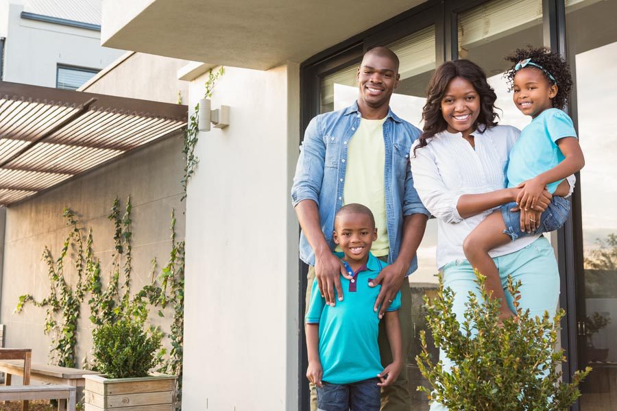 Personal Insurance - Family Standing in Front of Their Modern Home